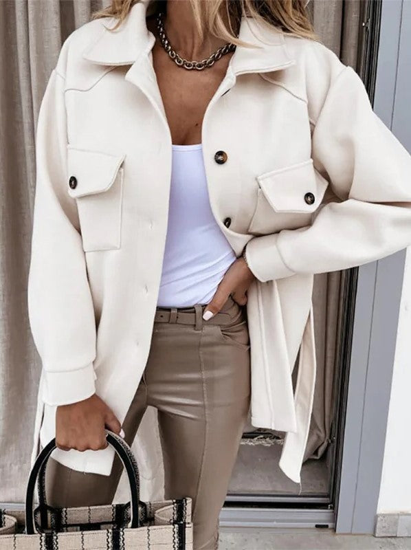 Elegante oversized jas gecombineerd met een witte top en leren broek.