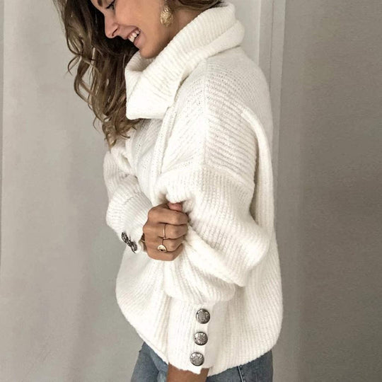 Lotte Vrouwelijke warme coltrui met een gebreid ontwerp en knopen op de mouwen. Deze trui biedt comfort en stijl, perfect voor een gezellige look tijdens de koudere maanden.