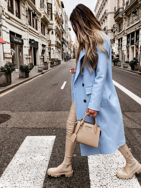 Elise's Dames Klassieke Lange Jas Winterjas, perfect voor een klassieke en verfijnde look tijdens koude dagen. De jas heeft een stijlvolle snit met dubbele knopen, gecombineerd met een modieuze handtas en hoge laarzen voor een complete winterse outfit. Ideaal voor zowel formele als casual gelegenheden waar comfort en klasse samenkomen.