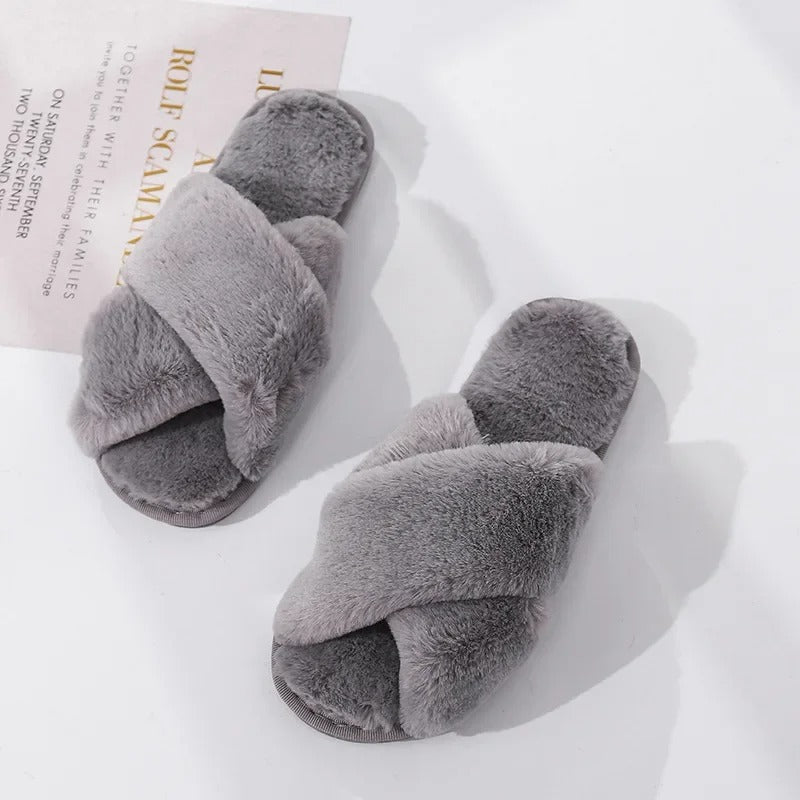 Voeten gehuld in comfortabele en warme pantoffels met kruisontwerp.